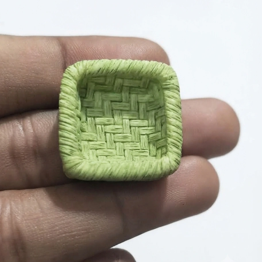 Miniature-Green-Woven-Basket Miniature green woven basket, a beautifully crafted product for dollhouse enthusiasts and collectors.