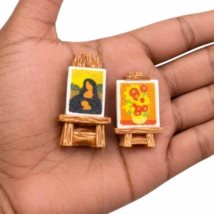 Miniature easel product set with two tiny paintings, ideal for dollhouse art studios or creative displays.