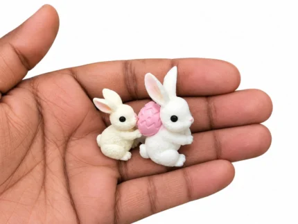 Charming miniature rabbit pair with a pink Easter egg, perfect for dollhouse scenes, this product.