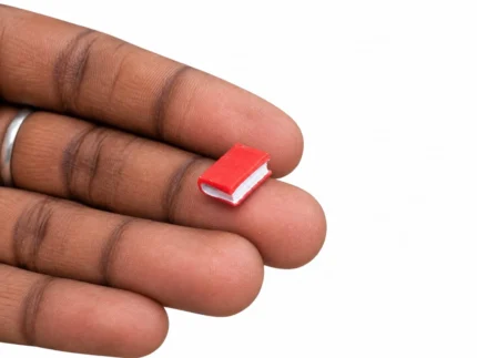 Detailed miniature red book figurine product for dollhouse libraries, miniature scenes, or collectors.